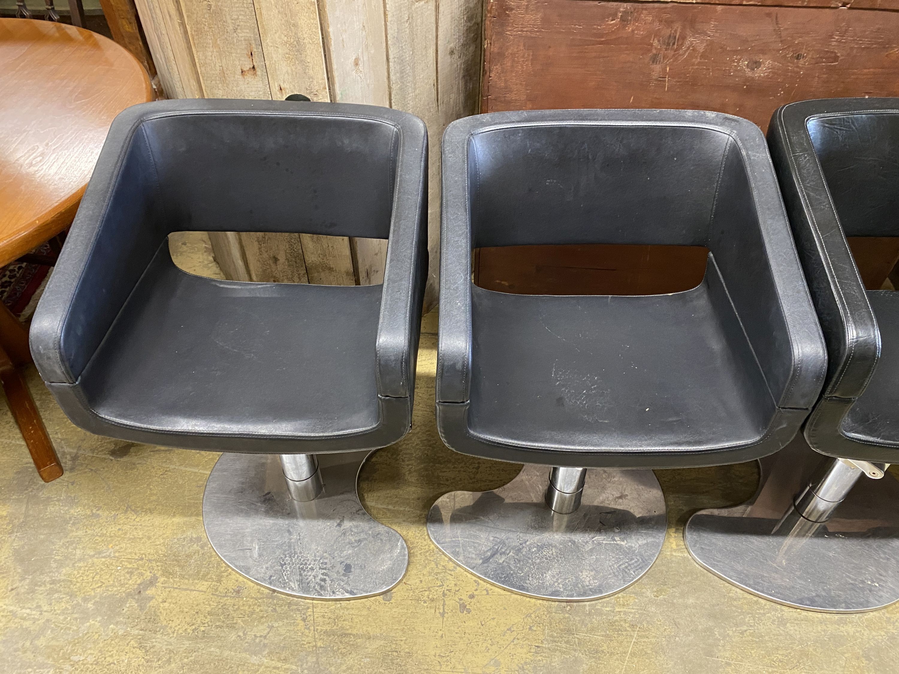 A set of five REM black leatherette and chrome hydraulic salon chairs, width 56cm, depth 42cm